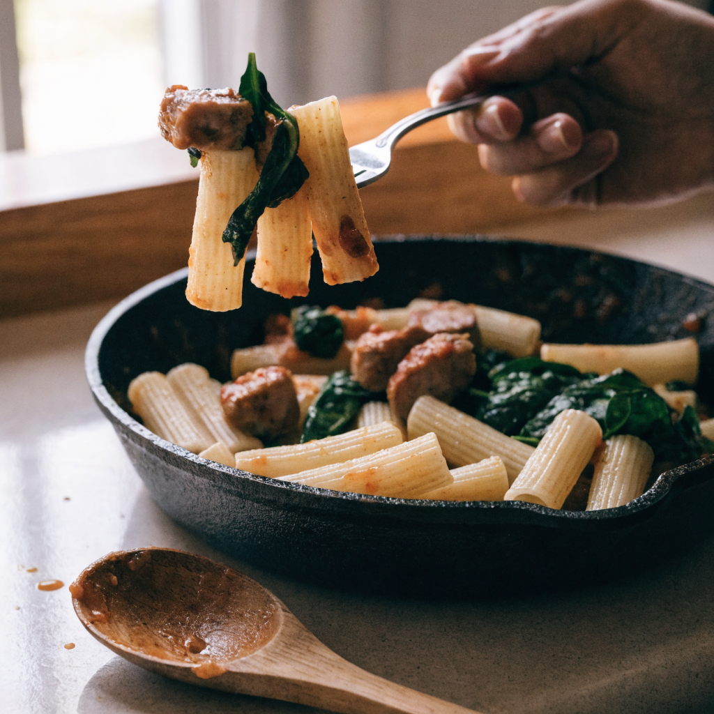 Close-up of creamy sausage rigatoni with spinach and tomato cream sauce
